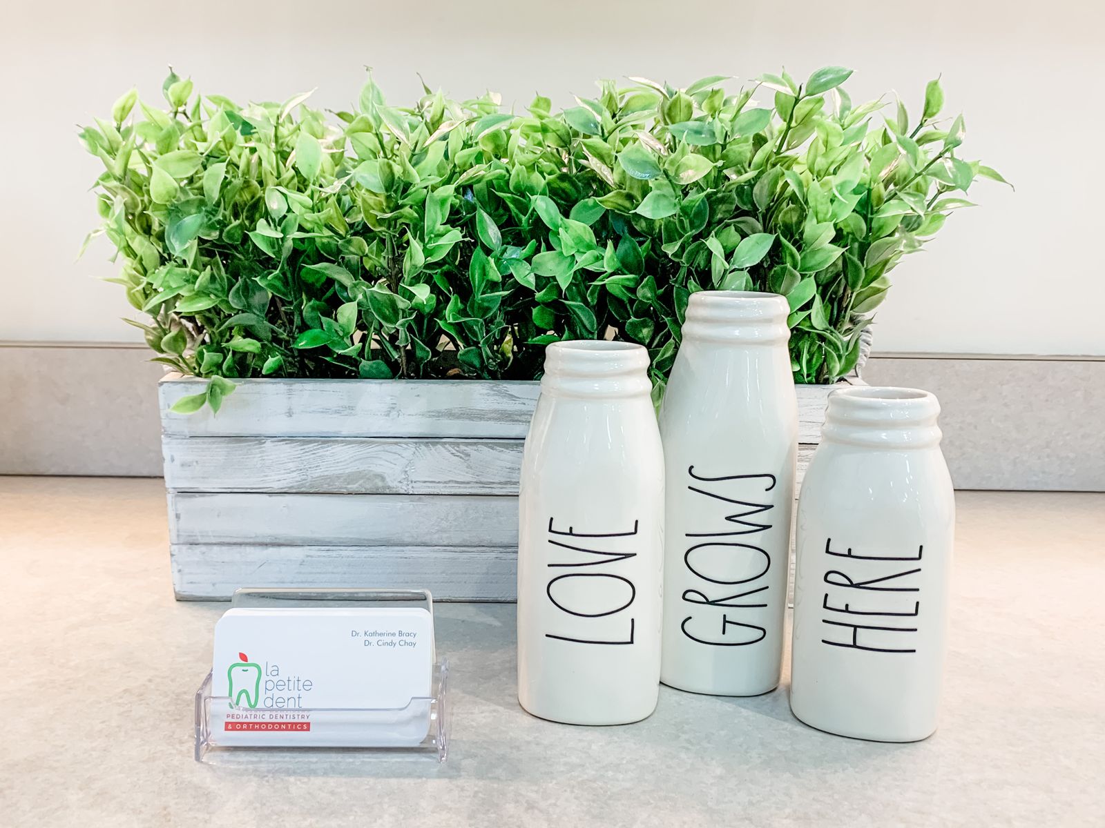 Milk-bottle vases in the La Petite Dent office spelling Love Grows Here